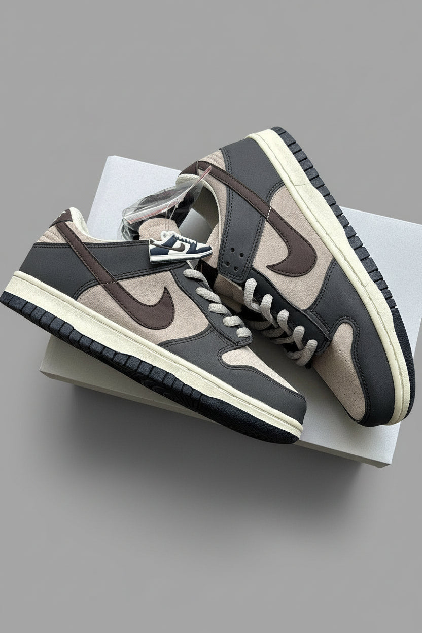 Pair of brown and black sneakers on a gray wooden surface