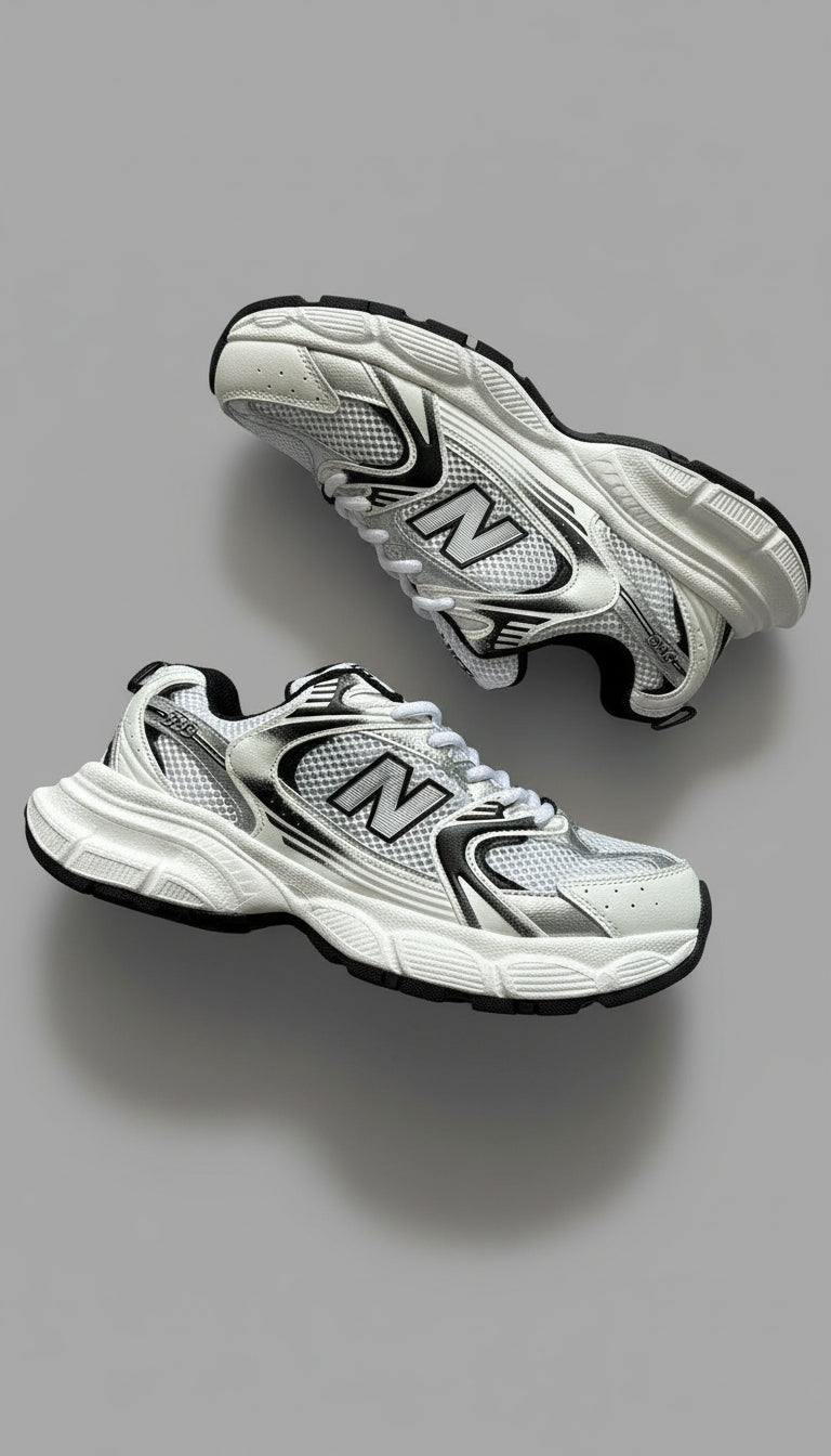 Pair of white and black running shoes on a gray concrete floor
