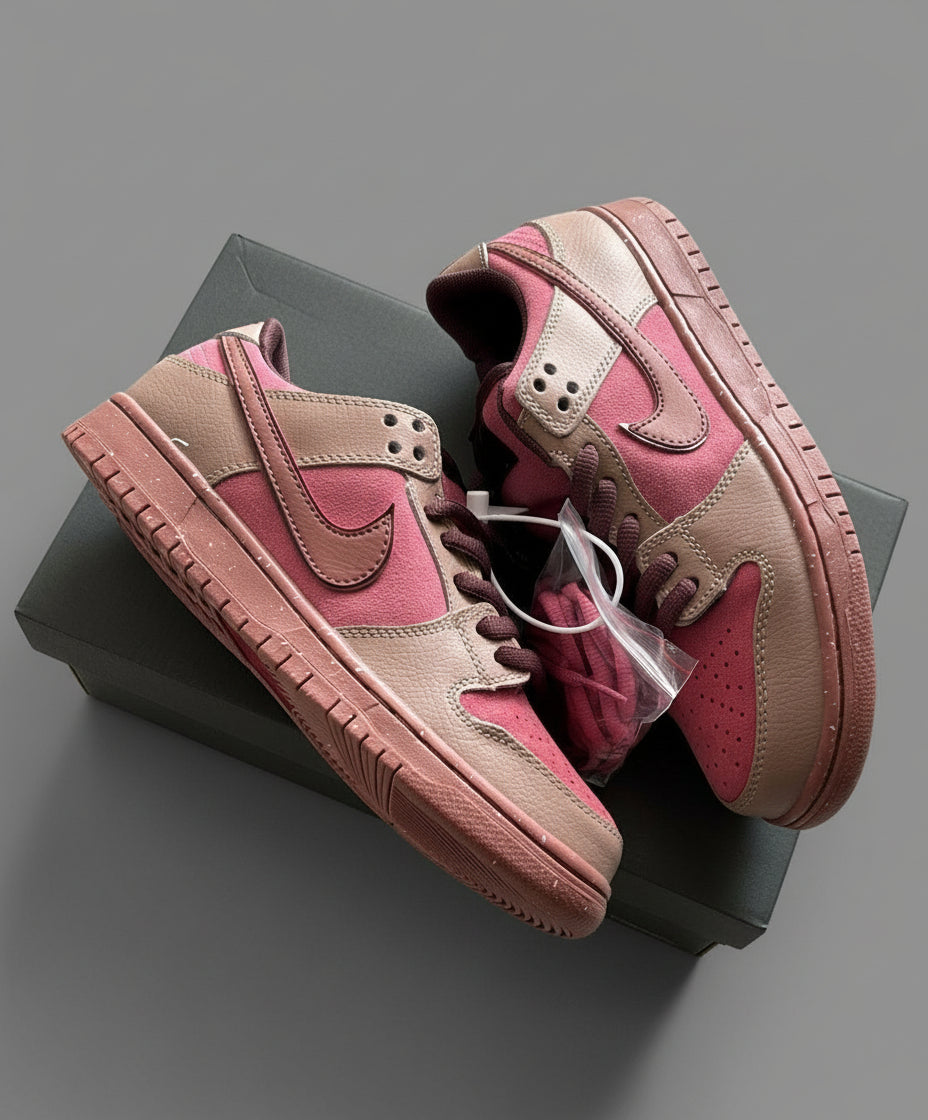 Pair of pink and brown sneakers on a black box with a light gray marble background