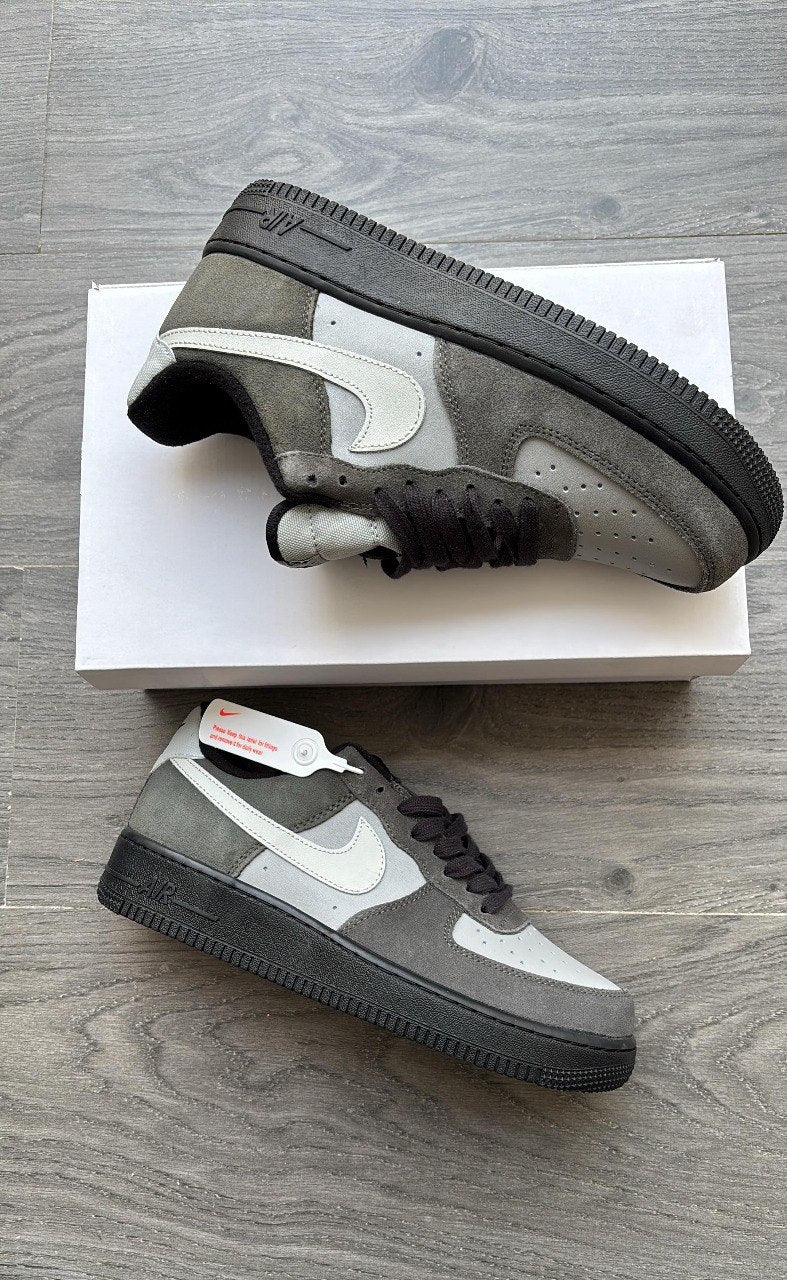 Gray and black sneakers with white accents on a wooden floor