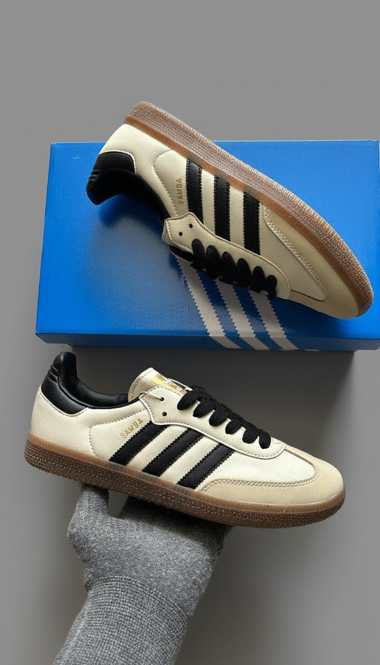 Beige sneakers with black stripes on a blue box, gray socks visible