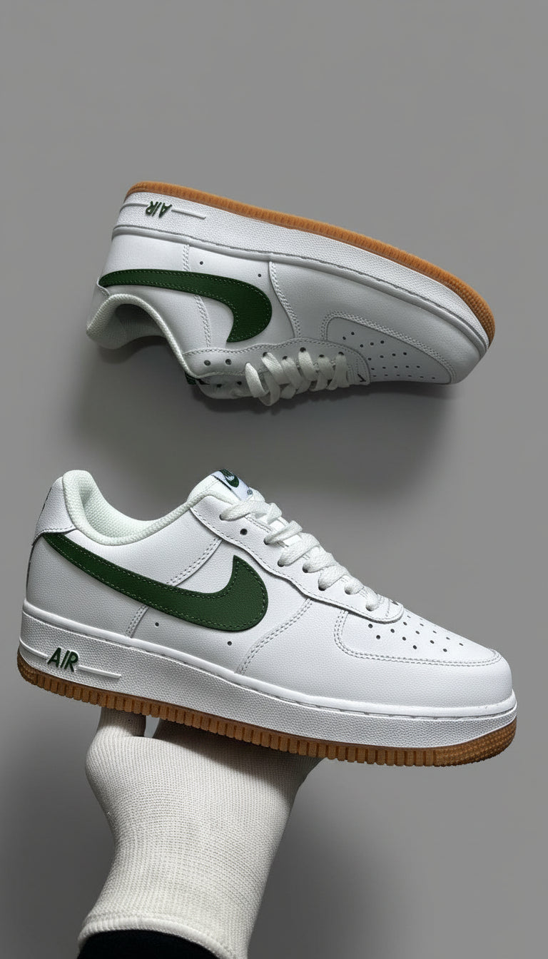 White sneakers with green accents worn by a person on a gray concrete floor