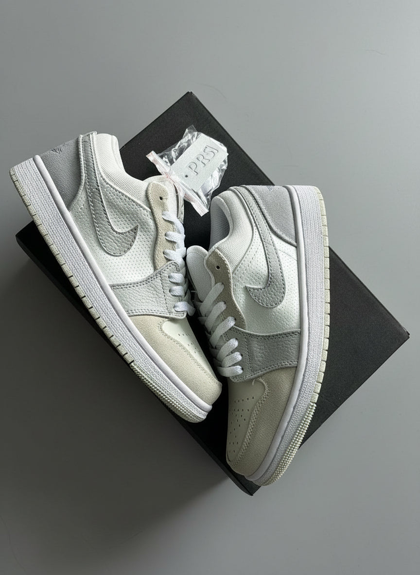 Pair of white sneakers with a grayish tint on a dark surface.