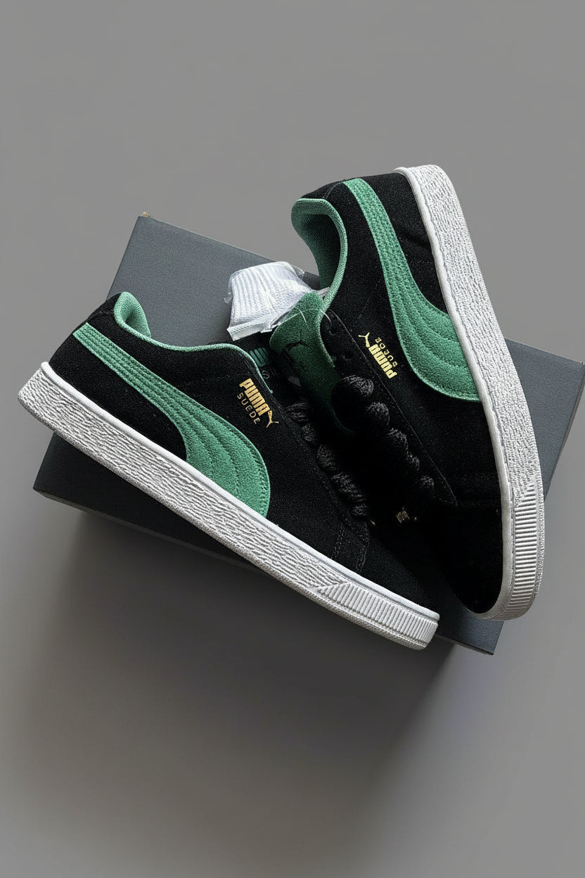 Black and green Puma sneakers on a gray surface