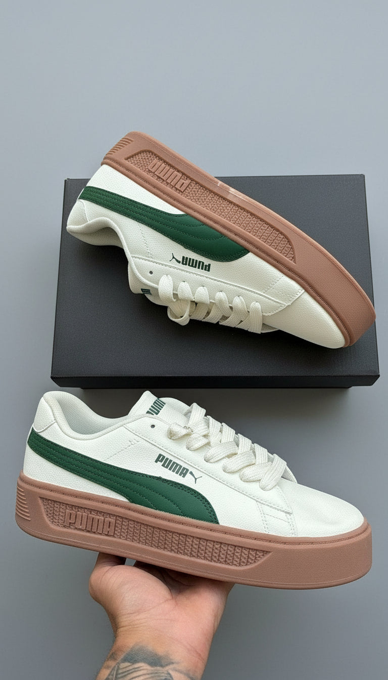 White and green sneakers with brown soles on a gray surface