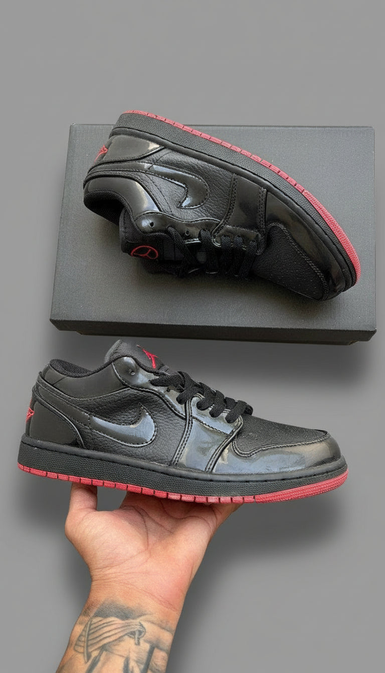 Black and red sneakers with a Nike logo on a gray wooden surface