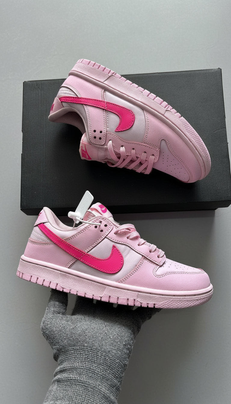 Pink sneakers with a Nike logo on a gray surface