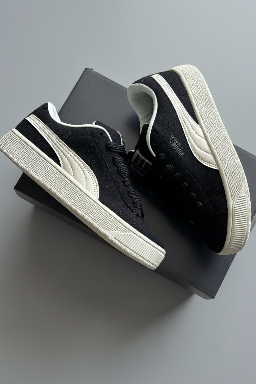 Black and white sneakers on a textured gray surface